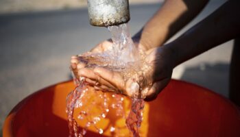 mujer africana vertiendo agua recipiente al aire libre 350x200 - Claves para entender el funcionamiento de una bomba de agua